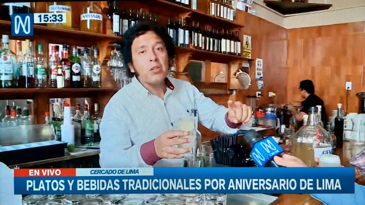 Pedro González Toledo muestra un pisco sour durante un enlace en vivo de televisión en una barra del Cercado de Lima